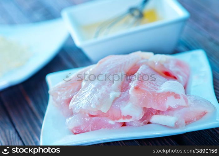 flour, raw egg and raw fish on a table