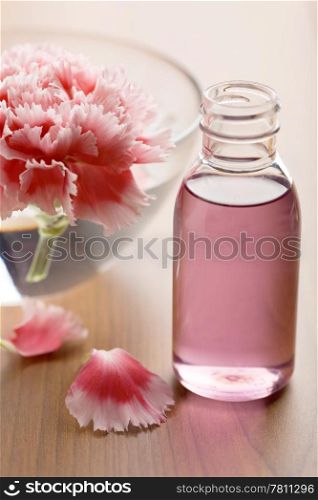 flower and essential oil in bottle. spa and body care background