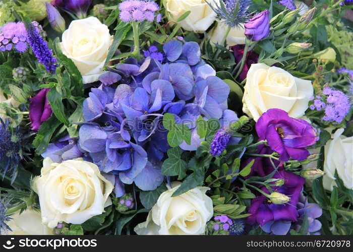 Flower arrangement in blue and white with hydrangea and roses