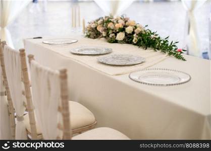 Flower arrangement in the center of the table, on which there are plates