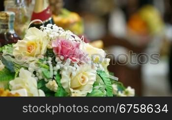 Flower arrangement on the wedding diner table in the background guests