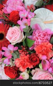 Flower arrangement with various flowers in different shades of red and pink