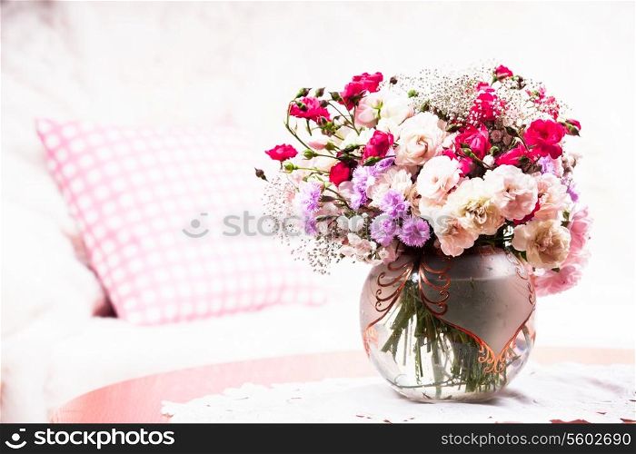 Flower bouquet on the table near the sofa with a pillow