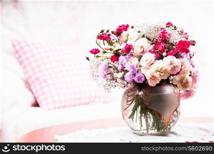 Flower bouquet on the table near the sofa with a pillow