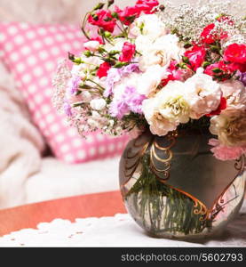 Flower bouquet on the table near the sofa with a pillow