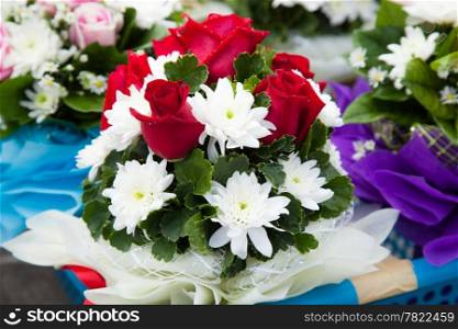 Flower bouquet with white roses and placed in a basket for flowers.