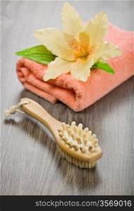 flower on pink towel with massager and brush