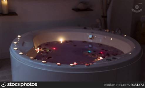 flower petals spa tub with violet water burning candles edges
