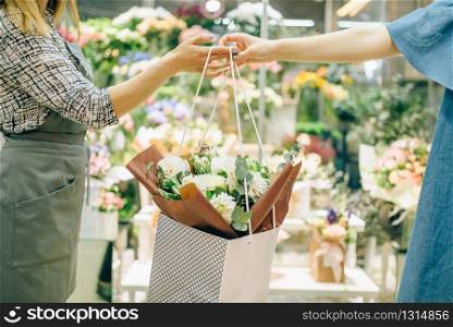 Flower shop business concept, florist in apron and female customer in floral boutique.. Flower shop business concept, florist and customer