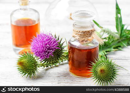 Flowering buds plant Thistle, and a small bottle of medicinal tincture