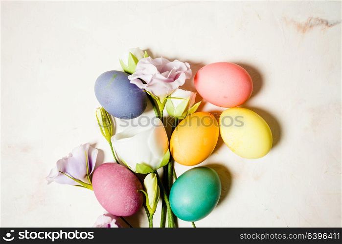Flowers and eggs on pink mable background, copy space for Easter greetings. Flowers and eggs