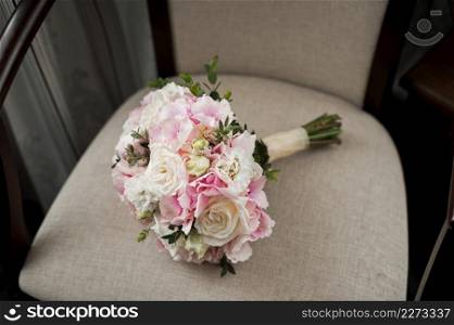 Flowers are lying on a beautiful chair.. A bouquet on a beige armchair 3981.