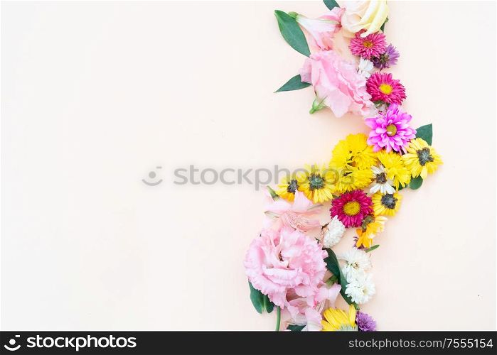 Flowers composition. Boder made of lilly, daisy and eustoma flowers on pink background. Flat lay, top view scene.. Ranunculus flat lay composition