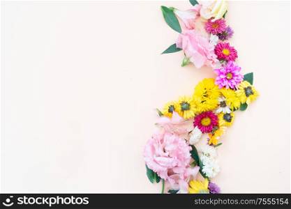Flowers composition. Boder made of lilly, daisy and eustoma flowers on pink background. Flat lay, top view scene.. Ranunculus flat lay composition