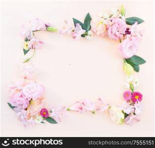Flowers composition. Frame made of eustoma, lilly and daisy flowers on pink background. Flat lay, top view scene.. Ranunculus flat lay composition