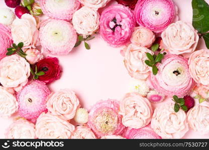Flowers composition. Frame wreath made of roses and ranunculus flowers on pink background. Flat lay, top view with copy space. Flowers flat lay composition