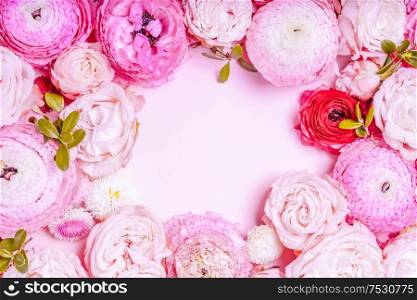 Flowers composition. Frame wreath made of roses and ranunculus flowers on pink background. Flat lay, top view, toned. Flowers flat lay composition
