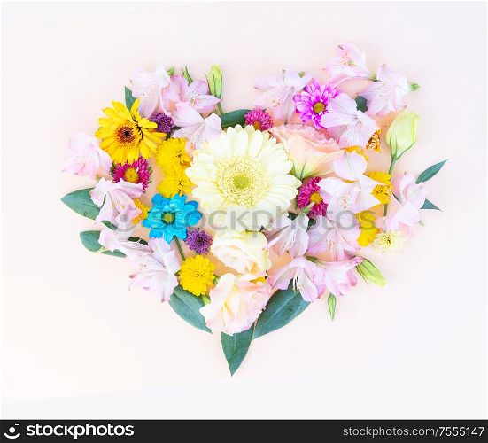 Flowers composition in the shape of heart made of eustoma and daisy flowers on pink background. Flat lay, top view scene.. Ranunculus flat lay composition
