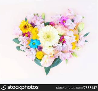 Flowers composition in the shape of heart made of eustoma and daisy flowers on pink background. Flat lay, top view scene.. Ranunculus flat lay composition
