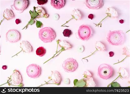 Flowers composition. Pattern made of roses and ranunculus flowers on pink background. Flat lay, top view. Flowers flat lay composition