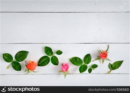 Flowers composition. Red roses on a white wooden background. Flat lay, top view. Free space for text.
