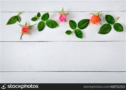 Flowers composition. Red roses on a white wooden background. Flat lay, top view