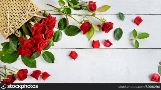 Flowers composition. Red roses on a white wooden background. Flat lay, top view. Free space for text.