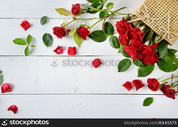 Flowers composition. Red roses on a white wooden background. Free space for text. Flat lay, top view.