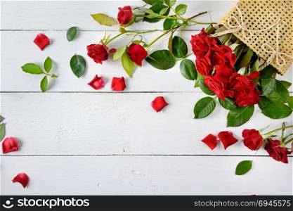 Flowers composition. Red roses on a white wooden background. Free space for text. Flat lay, top view.