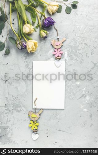 Flowers composition. Tulips flowers, paper blank on gray background. Spring concept. Flat lay, top view, copy space
