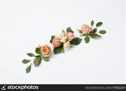 Flowers congratulation card with blooming roses flowers and green leaves on a light grey background, copy space. Valentine&rsquo;s Day concept.. Romantic flowering composition as a festive background.
