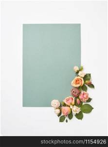 Flowers congratulation card with blossoming roses flowers and green leaves on a light grey background, copy space. Valentine&rsquo;s Day concept.. Romantic blooming greeting card with roses flowers.