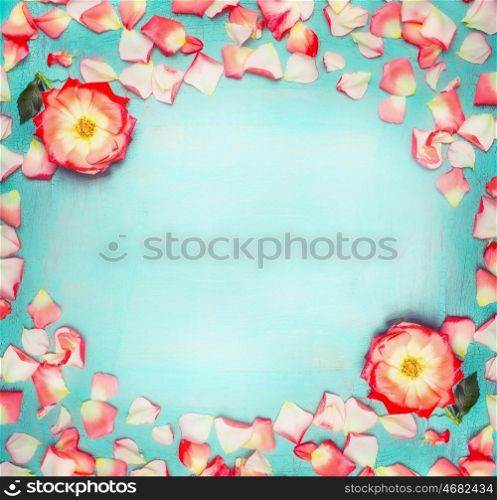 Flowers frame with roses and petals on turquoise blue shabby chic background, top view, place for text