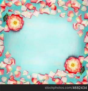 Flowers frame with roses and petals on turquoise blue shabby chic background, top view, place for text