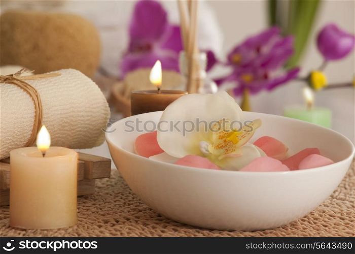 Flowers in a bowl with candles and bath scrub
