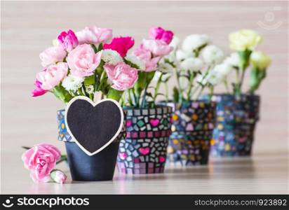 Flowers in the pot with blank wooden heart clothes pin