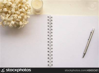Flowers, notebooks on a white wooden table that looks relaxed