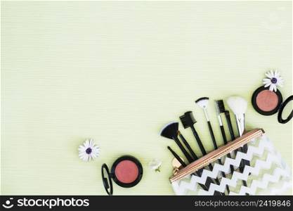flowers with makeup brushes compact face powder mint green backdrop