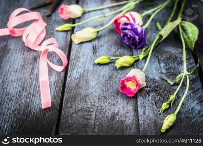 Flowers with ribbon on old blue wooden table