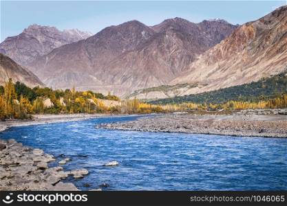 Flowing blue water of Gilgit River with mountains in the background, Gilgit-Baltistan, Pakistan.