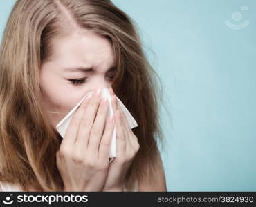 Flu cold or allergy symptom. Sick woman girl sneezing in tissue on blue. Health care.