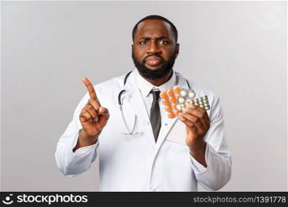 Flu, disease, healthcare and medicine concept. Angry serious-looking african-american doctor forbid taking pills, shaking finger scolding patient use drugs wrongly, frowning disappointed.. Flu, disease, healthcare and medicine concept. Angry serious-looking african-american doctor forbid taking pills, shaking finger scolding patient use drugs wrongly, frowning disappointed