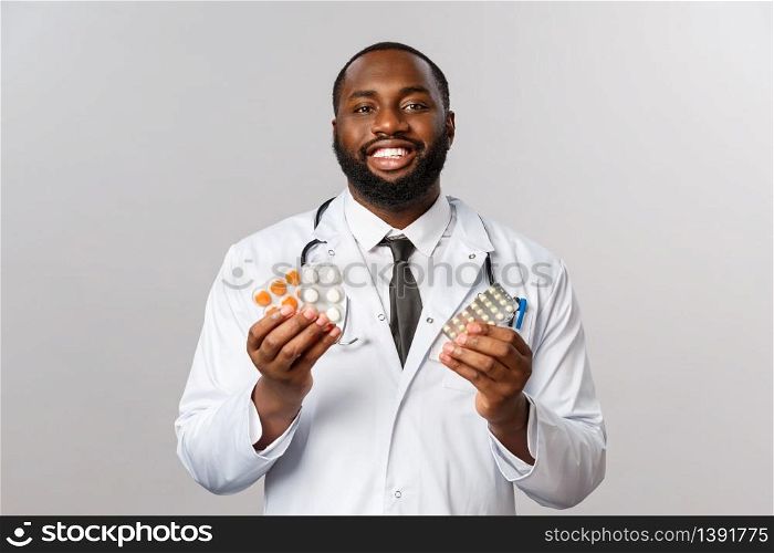 Flu, disease, healthcare and medicine concept. Handsome friendly-looking doctor, african-american physician showing pills and smiling, prescribe patient treatment from influenza, stay healthy.. Flu, disease, healthcare and medicine concept. Handsome friendly-looking doctor, african-american physician showing pills and smiling, prescribe patient treatment from influenza, stay healthy