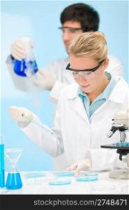 Flu virus experiment - scientist in laboratory with microscope, wear protective eyewear