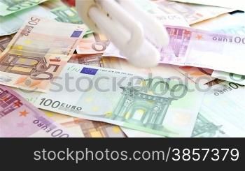 Fluorescent bulb against a background of euro bills.