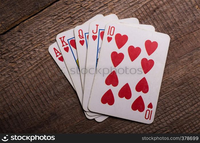 flush royal combination cards lying on a wooden table