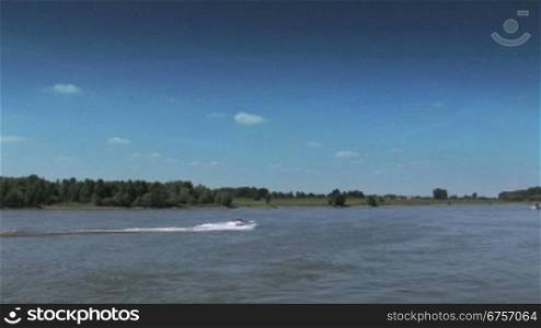 Flusslandschaft am Niederrhein und Sportboot auf dem Rhein