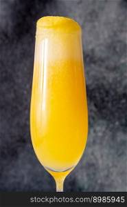 Flute Glass of Mango Mimosa cocktail on gray background