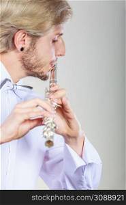 Flute music playing professional male flutist musician performer. Young elegant stylish man with instrument. Male flutist playing his flute