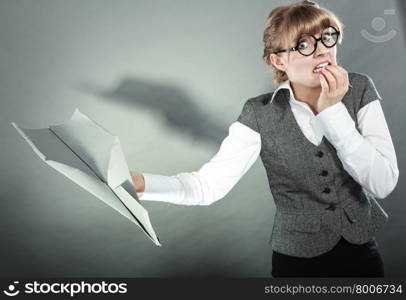 Fly fear metaphor, aerophobia concept. Business woman holding airplane in hand.